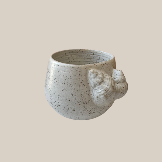 Beige keramik kop med konkylier