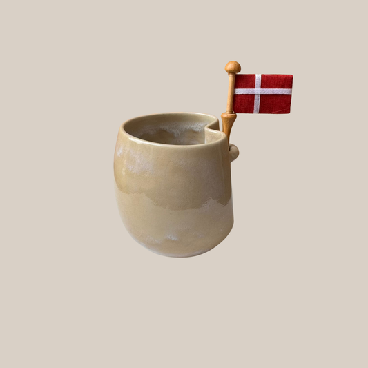 Lys naturfarvet keramik kop med tilhørende flag.