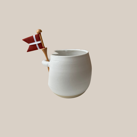 Hvid keramik kop med tilhørende flag.