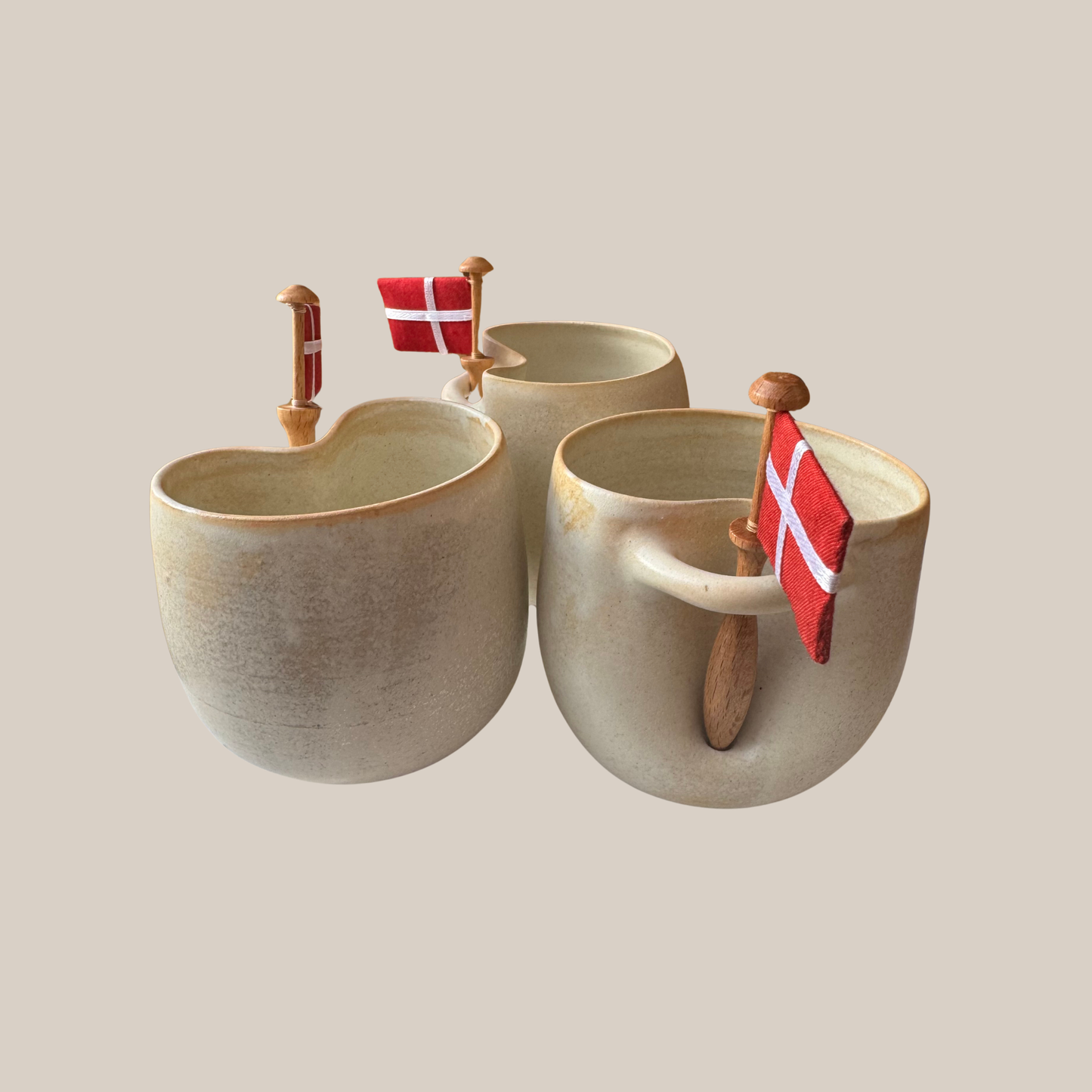 Flødefarvet keramik kop med tilhørende flag.