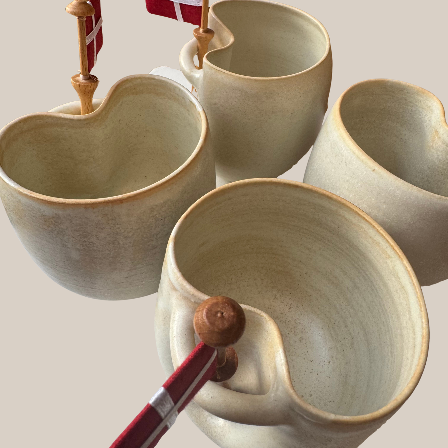 Flødefarvet keramik kop med tilhørende flag.