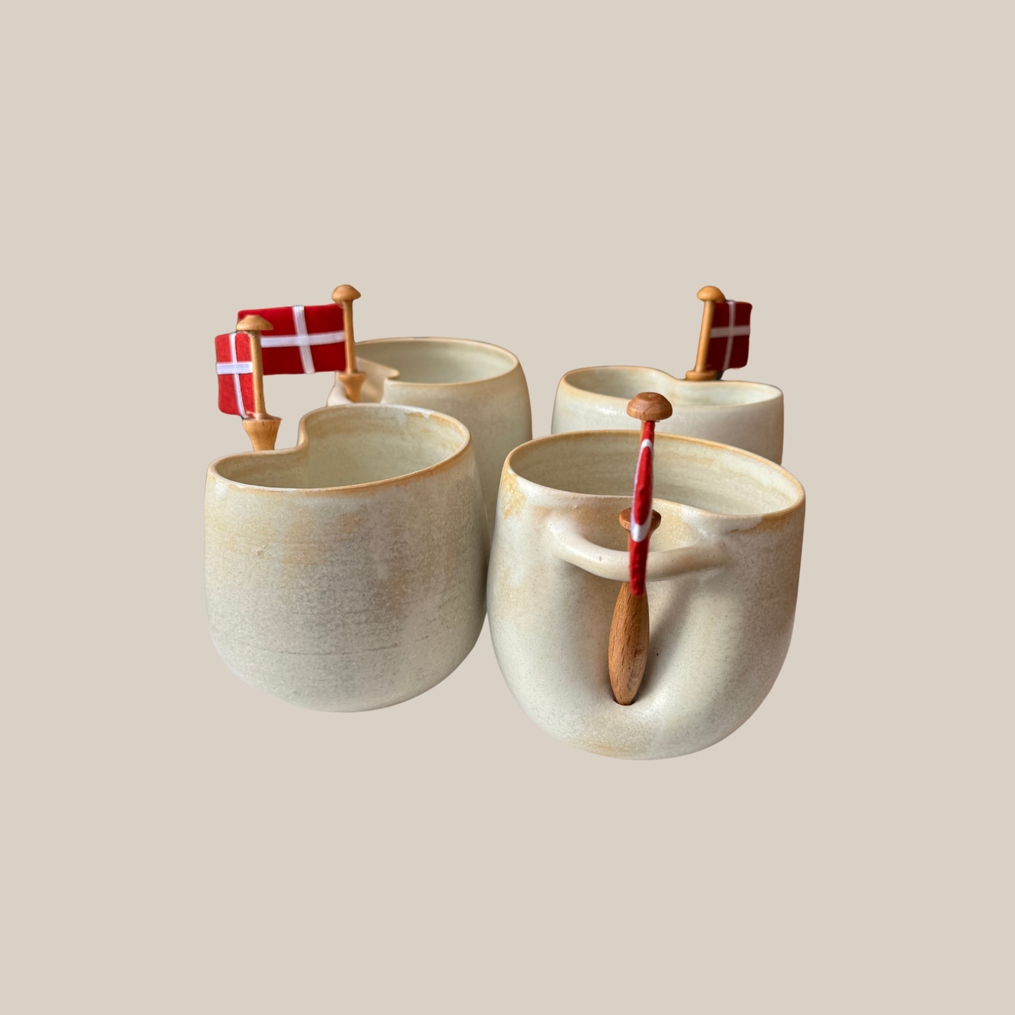 Flødefarvet keramik kop med tilhørende flag.