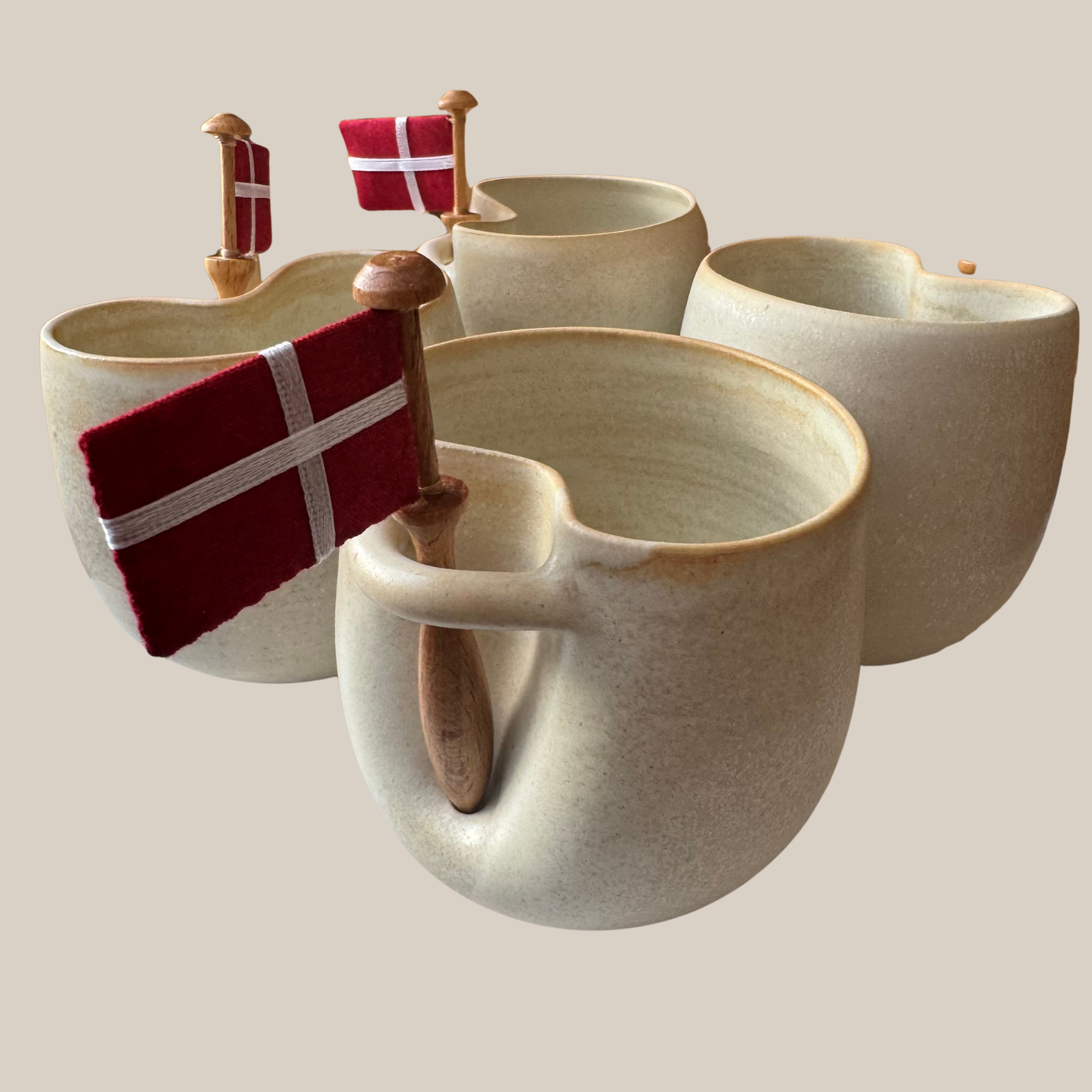 Flødefarvet keramik kop med tilhørende flag.