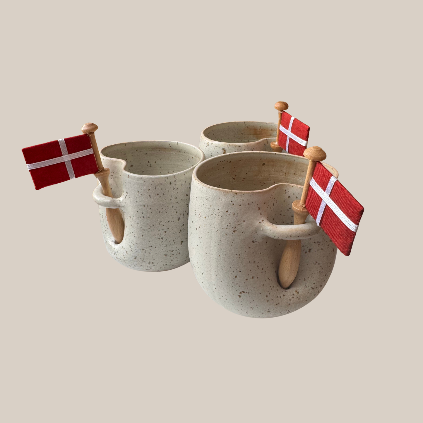 Lys beige prikket keramik kop med tilhørende flag.
