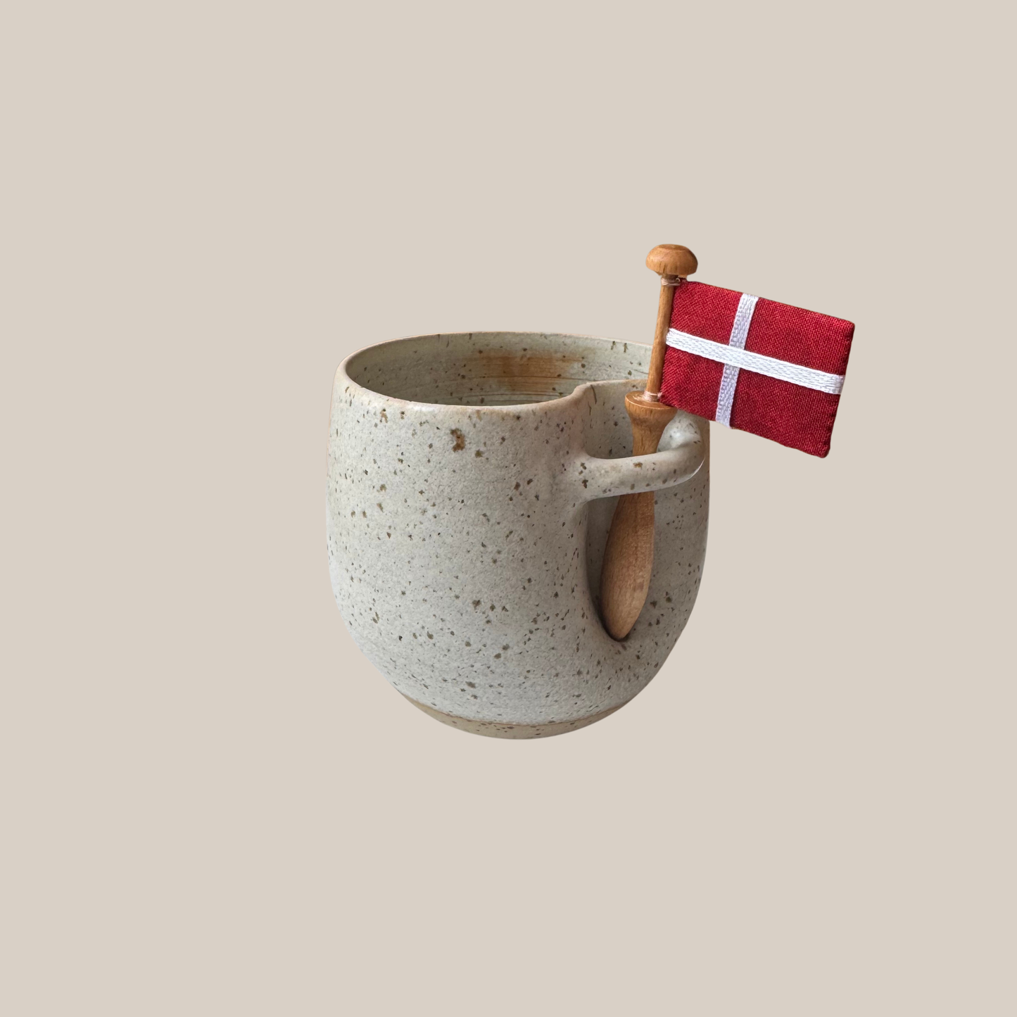 Lys beige prikket keramik kop med tilhørende flag.