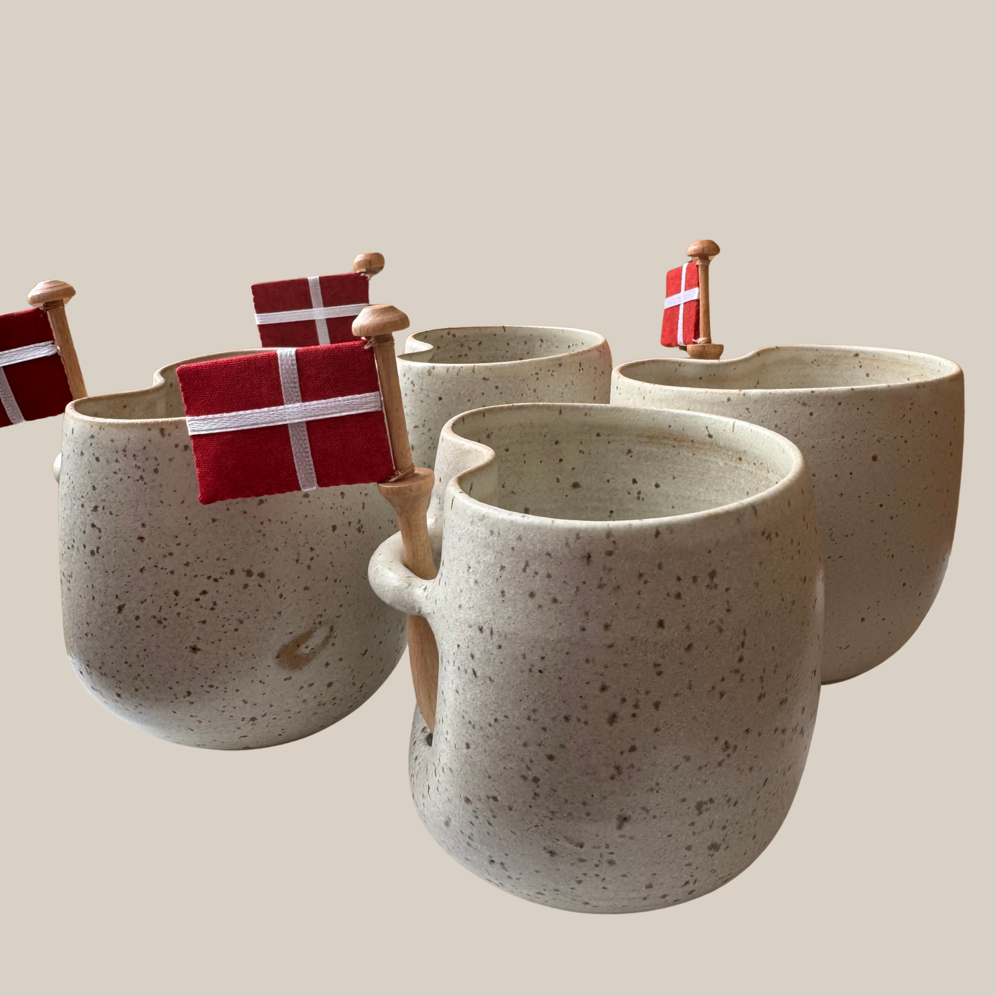 Lys beige prikket keramik kop med tilhørende flag.