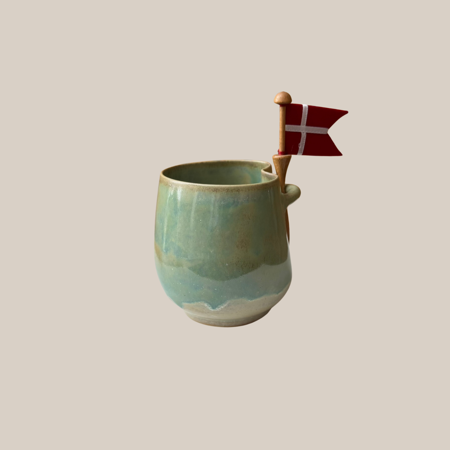 Grøn keramik kop med tilhørende flag.