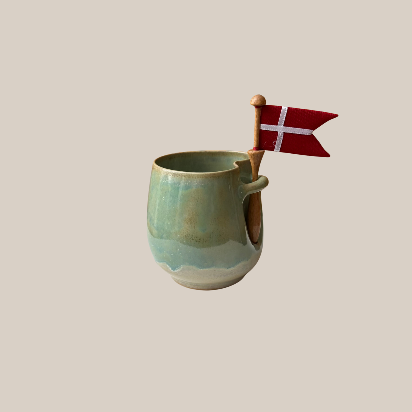Grøn keramik kop med tilhørende flag.