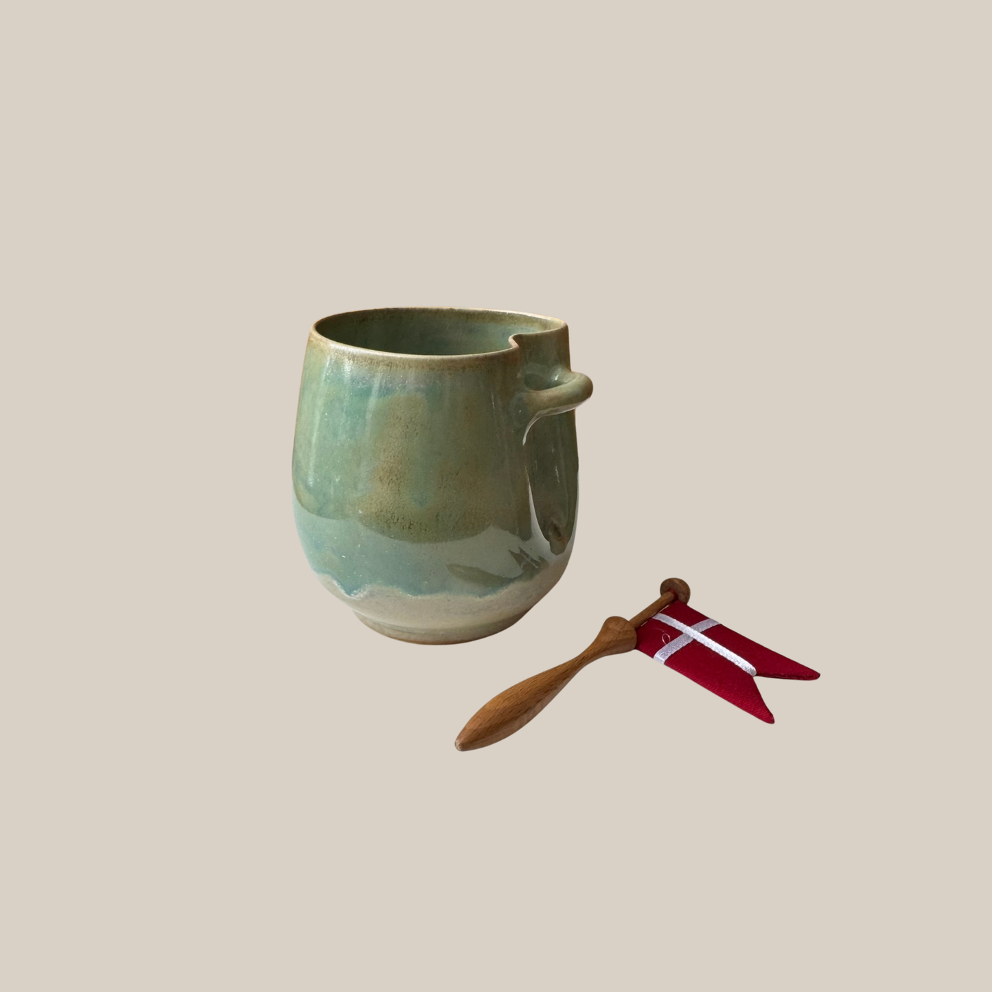 Grøn keramik kop med tilhørende flag.