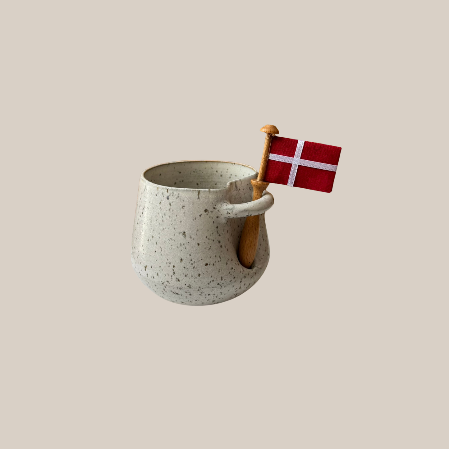 Lys beige keramik kop med tilhørende flag.