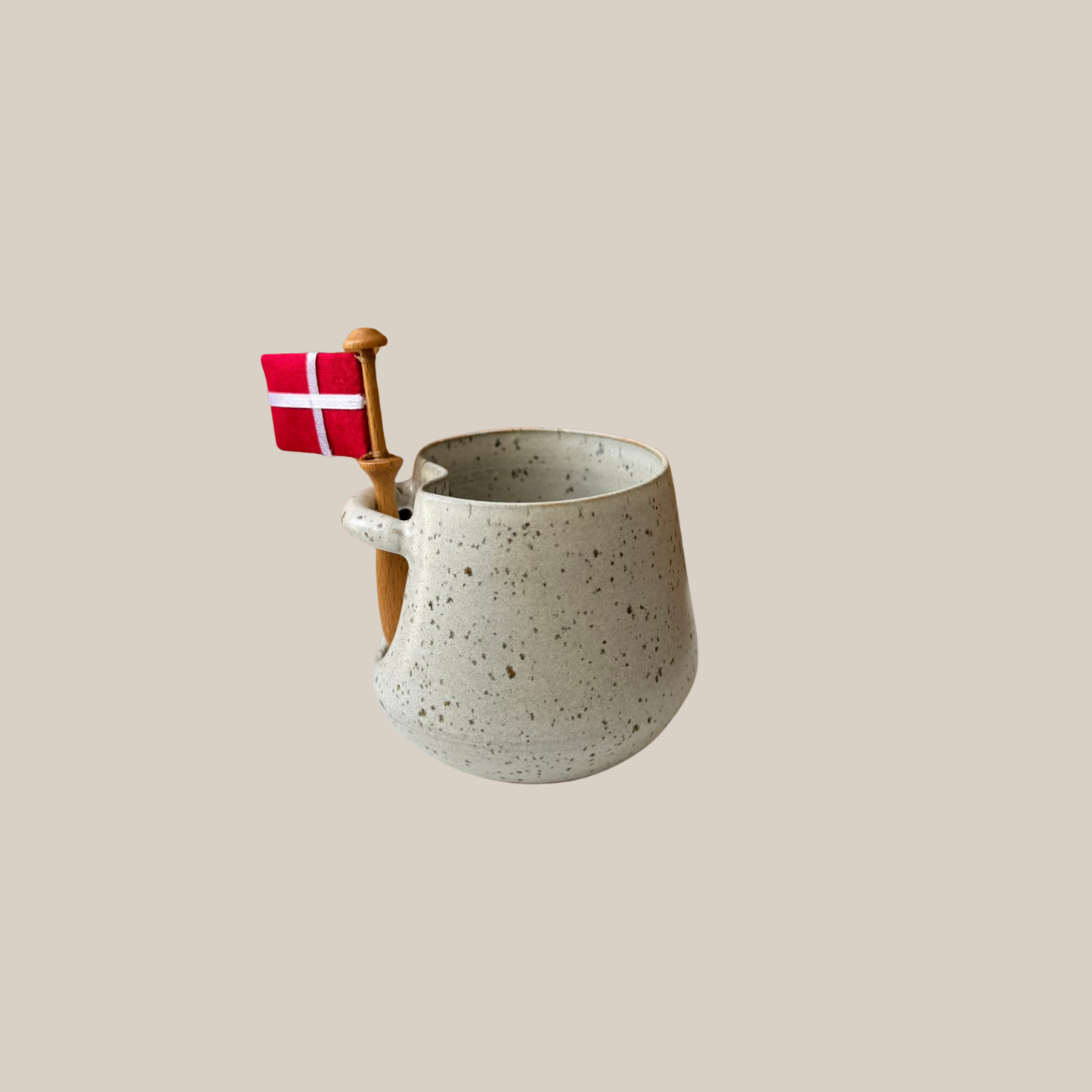 Lys beige keramik kop med tilhørende flag.