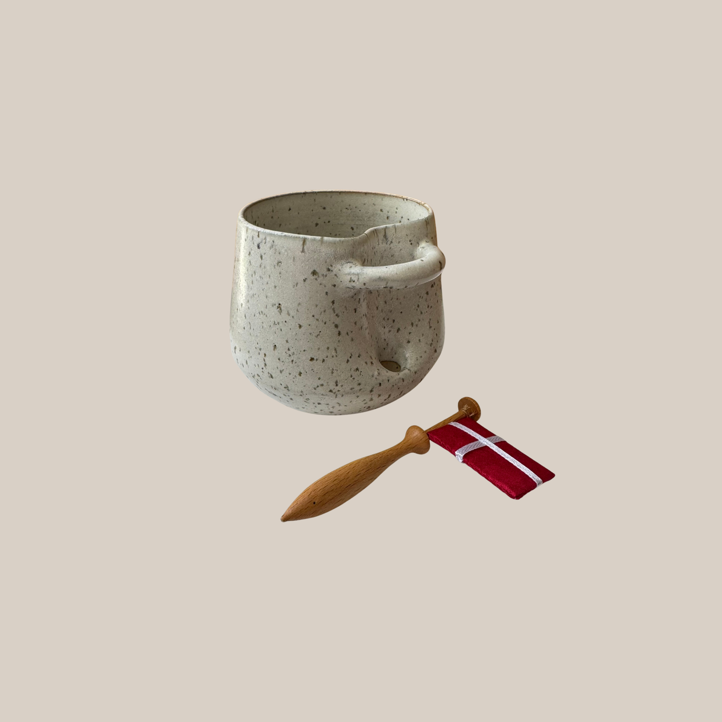 Lys beige keramik kop med tilhørende flag.