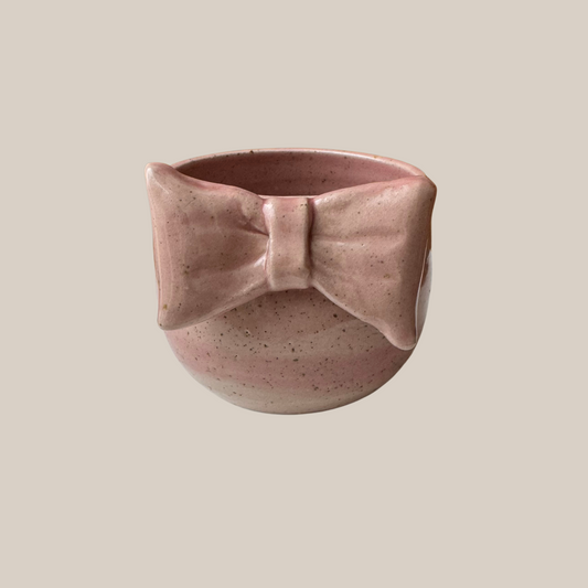 Rosa keramik kop med stor sløjfe.